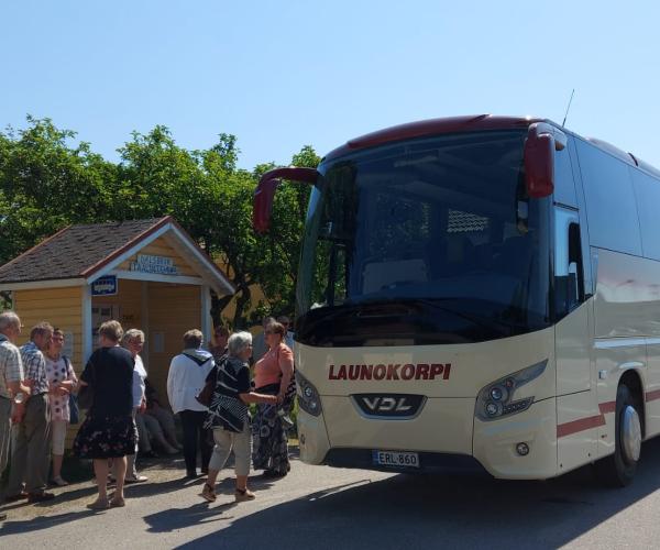 Launokorven bussi ja ihmisiä.