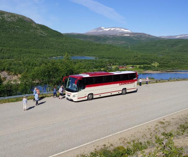Launokorven bussi tienposkessa ja ihmisiä.