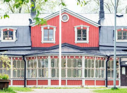 Puotilan kartanon punainen puurakennus ja lasikuisti.