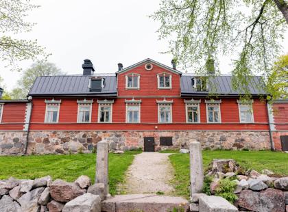 Puotilan kartanon punainen puurakennus takaa.