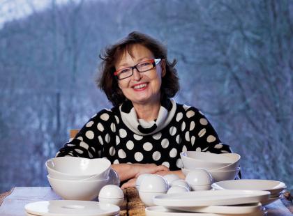 Karin Widnäs hymyilee keramiikka-astioiden takana