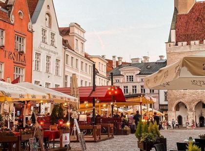 Tallinnan vanhankaupungin koristeellisia kivitaloja ja terasseja aukiolla.