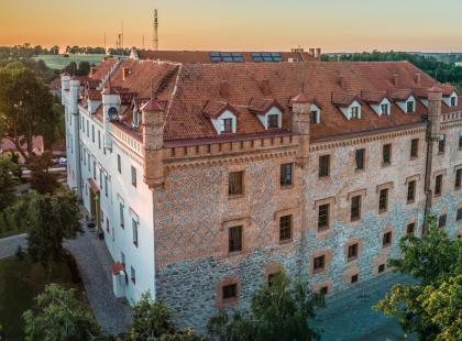 Hotel Zamek Rynin linnamainen rakennus ilta-auringossa.