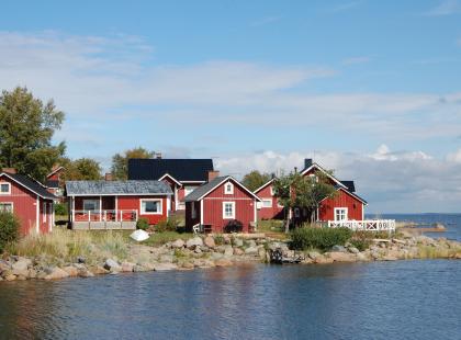 Ohtakarin kalastajakylän punaisia puutaloja meren rannalla.