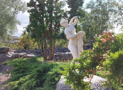 Källskärin puutarha - valkoinen patsas, puita, kiviaita