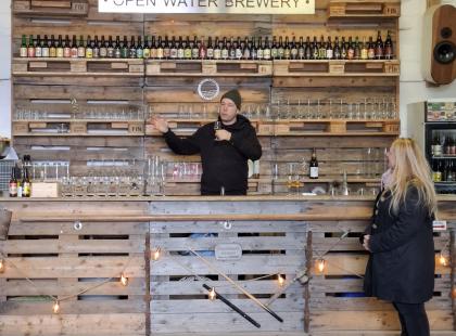 Open Water Brewery - puinen myyntitiski, pulloja hyllyillä