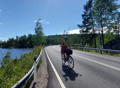 Pyöräilijä maantiellä, järvi