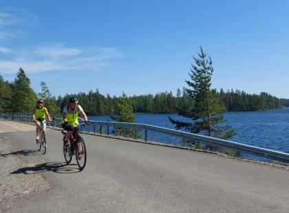 Pyöräilijöitä maantiellä, järvi