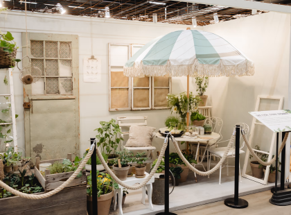 Puutarhaterassi vaalealla sisustuksella, pöytä, tuoleja, päivänvarjo, viherkasveja, vanha ovi