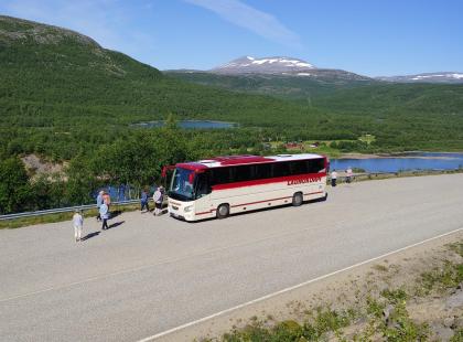 Launokorven bussi tienposkessa ja ihmisiä.