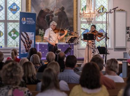 Viulisteja ja yleisö.